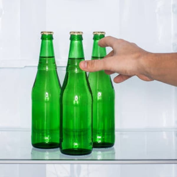 green glass beer bottles in refrigerator