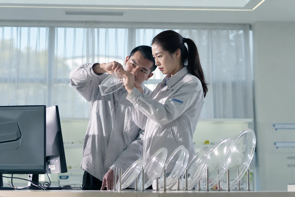 Two team members examining glassware during design and sample review; adapted from supplied service photography